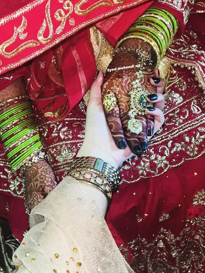 Masha Allah, look at that beautiful henna stain. This shot captures the rich, dark color of the mehndi a few days after application, perfectly complementing her bridal bangles and rings.