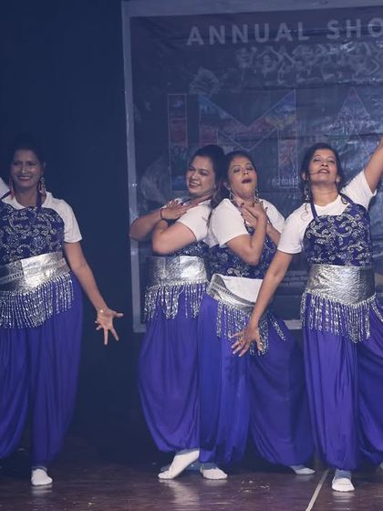 A fun, synchronized pose from the ladies' performance, full of personality and joy.