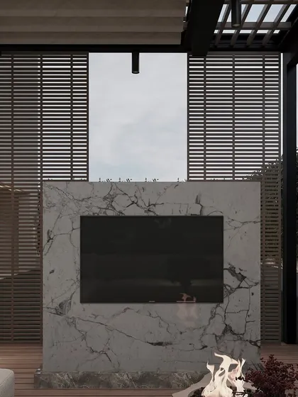 We integrated an outdoor entertainment system into this space, with a television mounted on a marble-clad feature wall above a fireplace. This allows the lounge to be used for movie nights or watching sports in the open air.