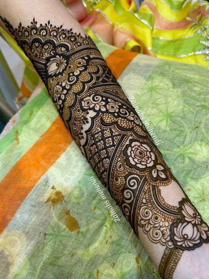 A detailed shot of the forearm portion of Zeba's bridal henna, featuring a mix of floral, geometric, and paisley patterns.