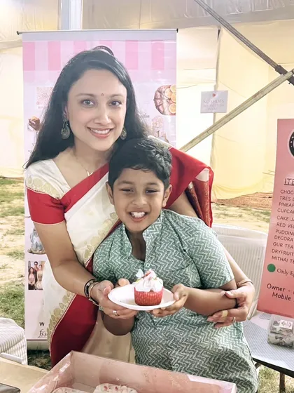 A sweet moment with my son at the Durgostav pop-up. He is my biggest supporter and loves tasting my creations, especially the red velvet cupcakes!