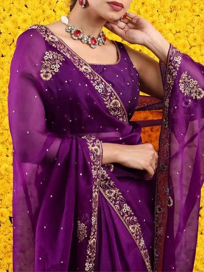 A stunning royal purple organza saree with intricate floral embroidery on the border and pallu.