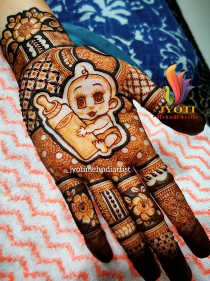 A detailed baby shower design featuring a cute baby figure with a milk bottle. The surrounding patterns are intricate and traditional, blending custom figure work with classic mehndi art.