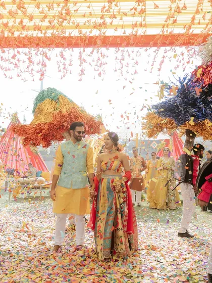 A wide-angle shot of the couple's grand entrance, showing the scale of the celebration and the vibrant decor.