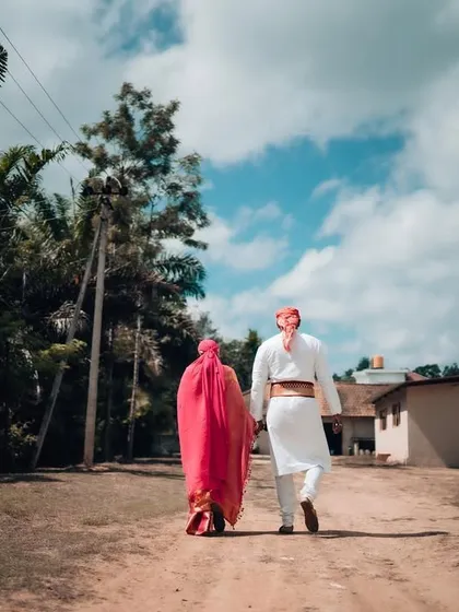 A couple in traditional wedding clothes walks away hand-in-hand, symbolizing the start of their new journey together. This is a classic cinematic shot we love to capture.
