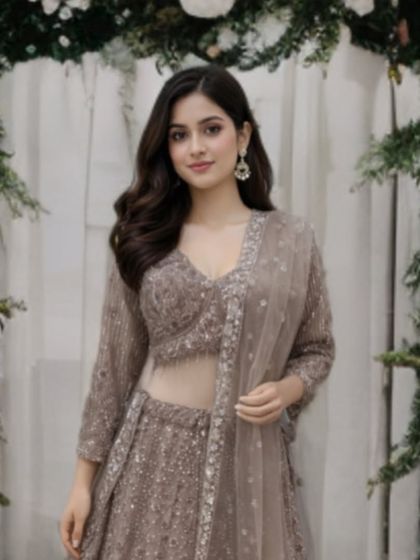 A close-up portrait in the taupe-brown lehenga, framed by a floral arch. This outfit is a unique and refined choice for a reception or engagement.