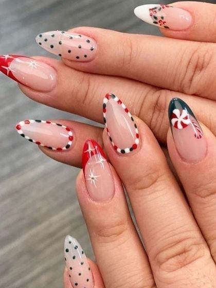 A chic and modern Christmas design on long, almond-shaped nails. This set features peppermint candy art, delicate polka dots, and sparkling star details, using a negative space technique for a trendy finish.
