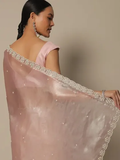 A shot from the Kalki Fashion catalogue. The sleek, low ponytail and soft makeup create a timeless look that highlights the delicate organza saree.