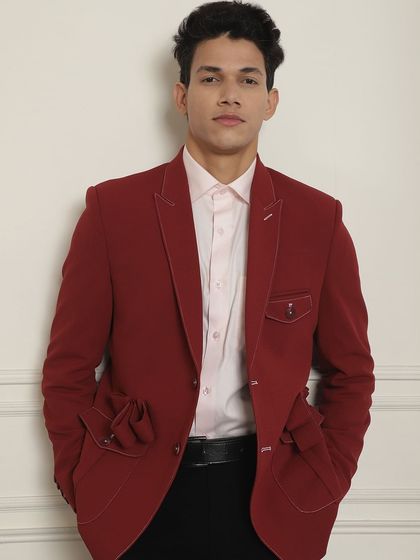 A close-up of our unique red blazer, featuring distinctive pocket details and contrast stitching.