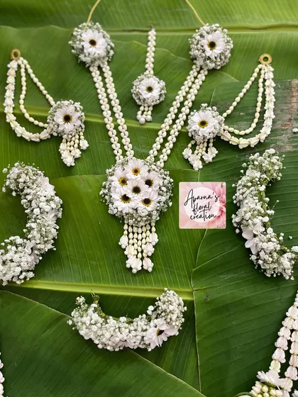 The full all-white floral set, showcasing the necklace with a central daisy cluster, matching earrings, and maang tikka.