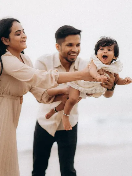 A moment of pure, uninhibited fun as parents playfully swing their laughing baby between them on the beach. Capturing these high-energy, joyful interactions is what makes family lifestyle photography so special.