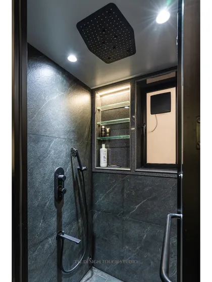 This modern bathroom features dark, dramatic tiles and a sleek, glass-enclosed shower. The design is bold, sophisticated, and perfect for a contemporary home.