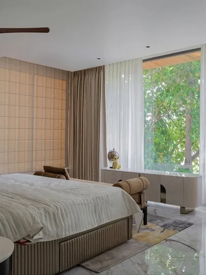 This kid's room from our Chennai project was designed to evolve with age. Layered in neutrals and softened with curves, the space features a custom bed, a sculptural armchair, and a large window with a view.