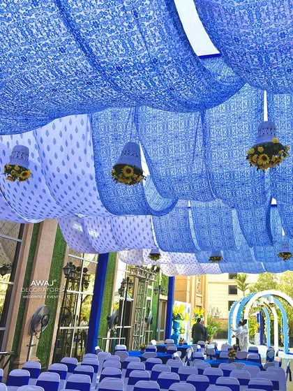 Looking up at the ceiling decor, with blue and white patterned fabrics creating a beautiful tent-like effect.