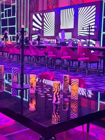 Funky and fabulous! This dining setup, with its bold pink chairs and graphic black-and-white backdrop, was part of an eclectic celebration that was anything but ordinary. 💥