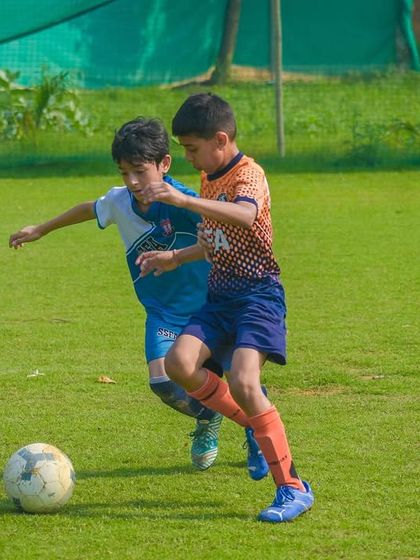 Two players battle for possession of the ball, demonstrating the grit and determination that we instill in all our athletes.