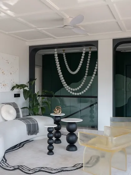 The lounge area on the upper floor of the Evelyn project is a space for unwinding. A sculptural white sofa, custom resin chairs, and abstract art create an environment that is both relaxing and visually stimulating.