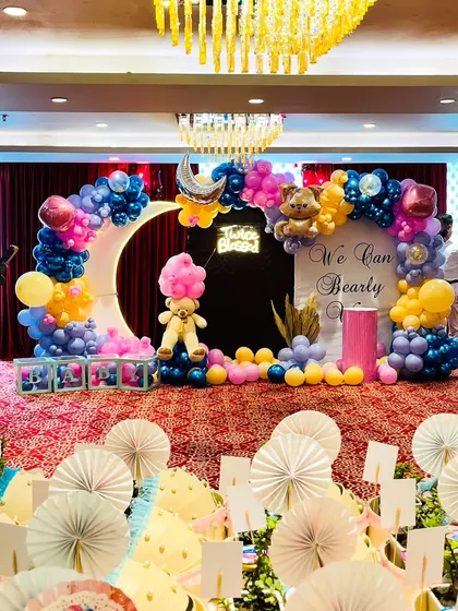 We love bringing adorable themes to life for baby showers. This "We Can Bearly Wait" setup for twins features a large crescent moon prop with an integrated balloon arch, teddy bear accents, a custom "Twice Blessed" neon sign, and a soft pastel color palette.