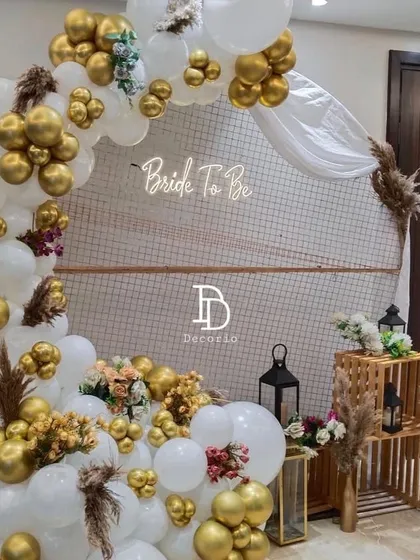 A classic and elegant choice for a bridal shower, this setup features a white and gold balloon arch against a simple backdrop. I added pampas grass and small floral arrangements for a touch of rustic charm.