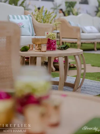 A detail shot of the lounge area at the Taj Palace wedding, showing the elegant wooden furniture and bowls of fresh flower petals.