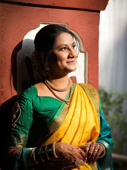 A sun-kissed photo of the bride, looking radiant and happy. The natural light enhances her glowing skin and the vibrant colors of her saree.