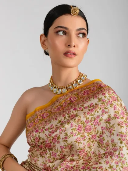 A classic look featuring a sharp, brown winged eyeliner and a sleek low bun. This makeup is paired with a floral yellow saree and a maang tikka for a timeless appeal.