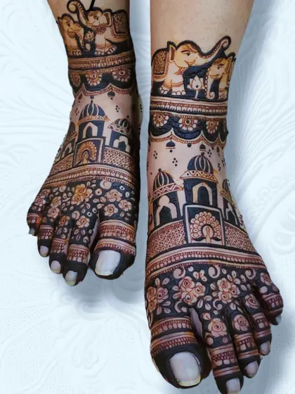 My bridal packages include full coverage for legs and feet. This design features grand palace architecture on the toes, surrounded by delicate floral work, with a band of royal elephants at the ankle.
