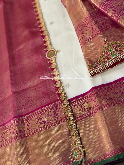 A detailed shot of the embroidered waist belt and sleeve cuff, designed to match the necklace pattern on the blouse.