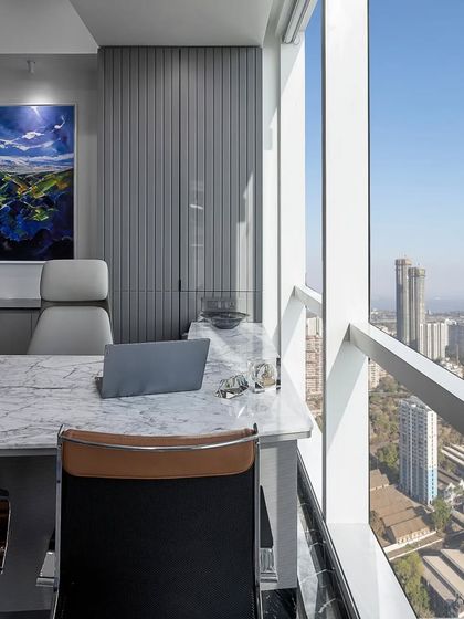 A wider view of the executive cabin, showcasing the balance between the workspace and the incredible city view. The automated blinds can be adjusted for light control without leaving the desk.