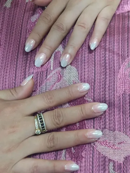 Another angle of the pearly chrome nails, which have a subtle ombre effect from a natural base to a soft white tip.