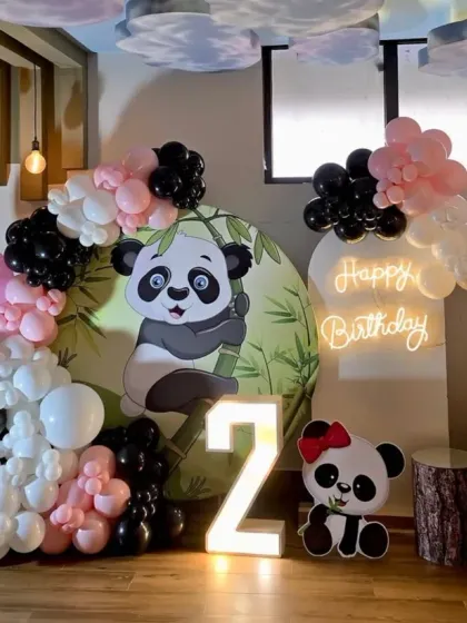 An adorable Panda theme for a second birthday, with a custom backdrop, panda cutouts, and a black, white, and pink balloon arch.