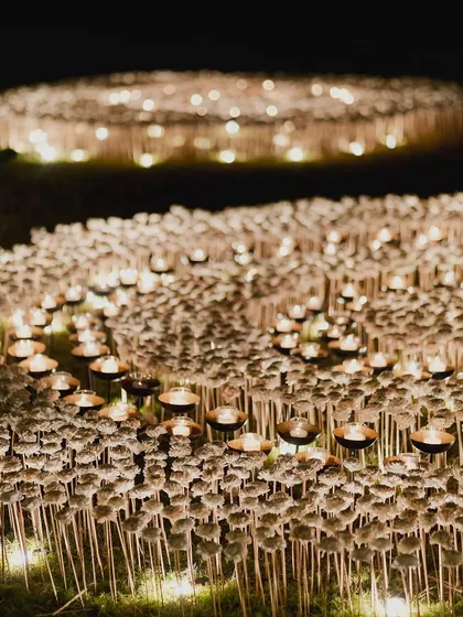 Artistry is at the core of what we do. For this event, we created a breathtaking outdoor installation featuring a field of countless candles and delicate white blooms, designed to evoke a sense of wonder and create an ethereal, glowing landscape under the night sky.