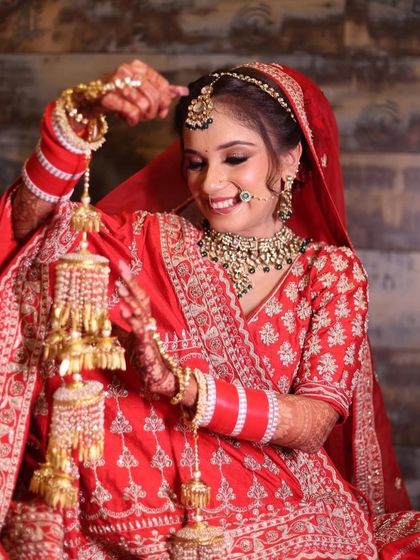 The bride playing with her kaleeras, a classic and joyful wedding moment.