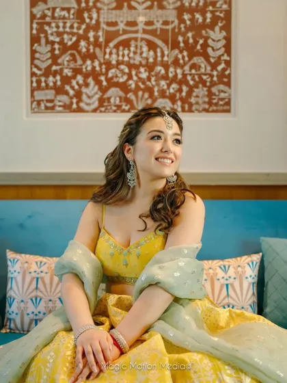 The Roka bride looking radiant, her simple hairstyle complementing her yellow lehenga.