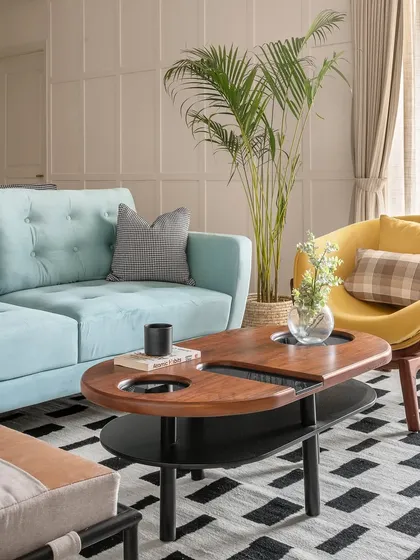 Part of our Zen Residence project, this living room uses pops of color, like the sky blue sofa and mustard armchair, to create a cheerful and modern atmosphere. The geometric rug and unique coffee table add a playful, contemporary touch.