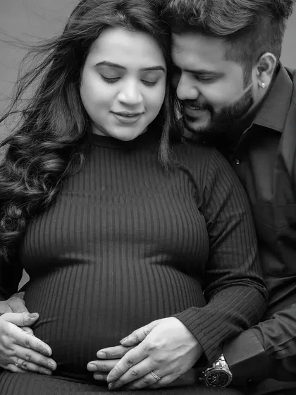 This intimate black and white close-up focuses on the couple's hands on the baby bump. It’s a powerful image that symbolizes their shared creation and the new life they are waiting for.