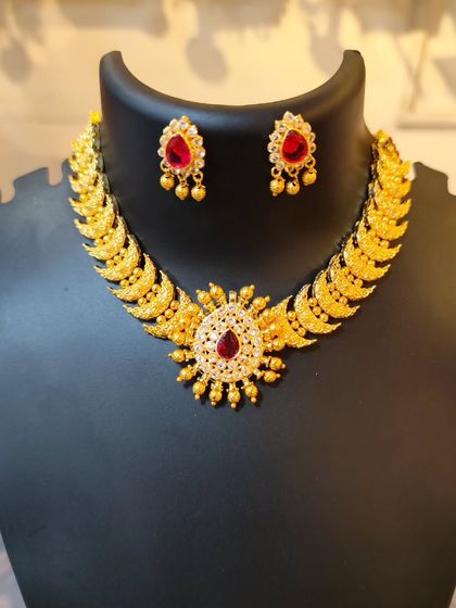 A beautiful choker with a sun-like pendant and red stones.