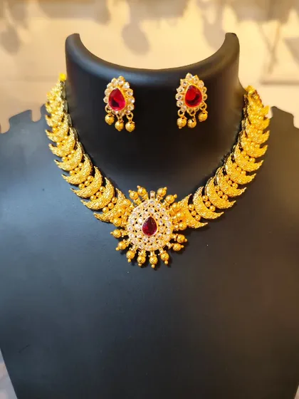A beautiful choker with a sun-like pendant and red stones.