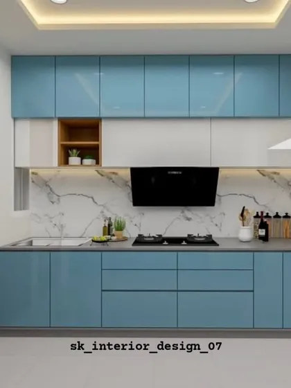 A sleek, straight-line kitchen with glossy blue handle-less cabinets. The white marble backsplash and countertop keep the space feeling bright and open.