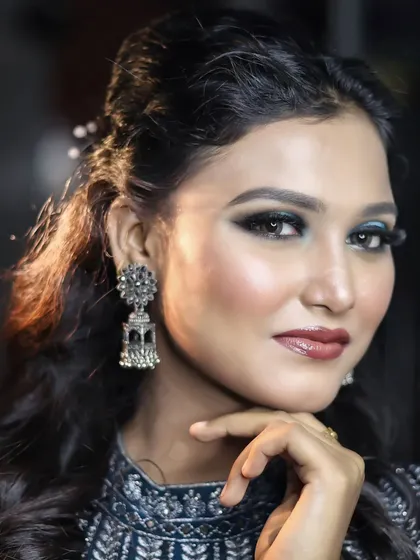 A classic pose that highlights the beautiful contrast between the cool-toned blue eyeshadow and the warm skin tones.