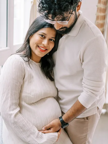 A warm and happy portrait of an expecting couple. Her leaning on his shoulder shows their support for one another during this journey. The genuine smiles are what make the photo special.