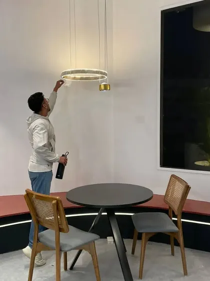 A team member making final adjustments to a decorative pendant light before the exhibition opened. Every detail is carefully considered to ensure our products and our brand are presented in the best possible light.