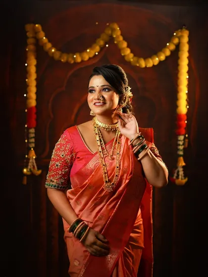 A happy, candid portrait of a woman celebrating Diwali, her face lit with joy as she poses in her traditional Maharashtrian attire.