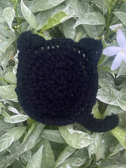 A close-up of my black cat coaster, perfect for your desk. It has little ears and a tail, and it's one of my favorite things to make.