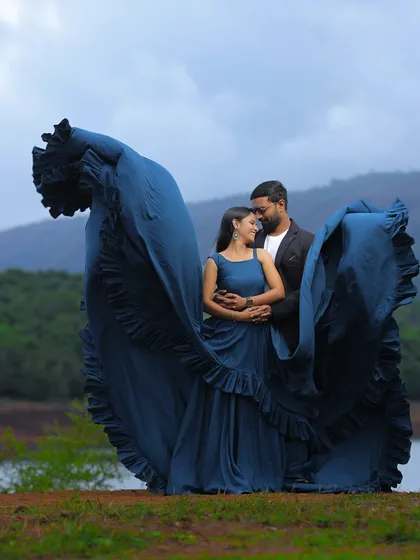 The "flying" trail of this blue gown creates a beautiful frame around the couple, making for a dramatic and artistic pre-wedding portrait.