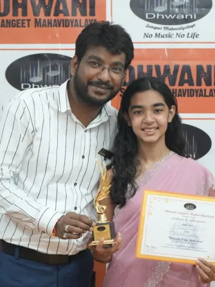 A teacher and his student share a proud moment with her award.