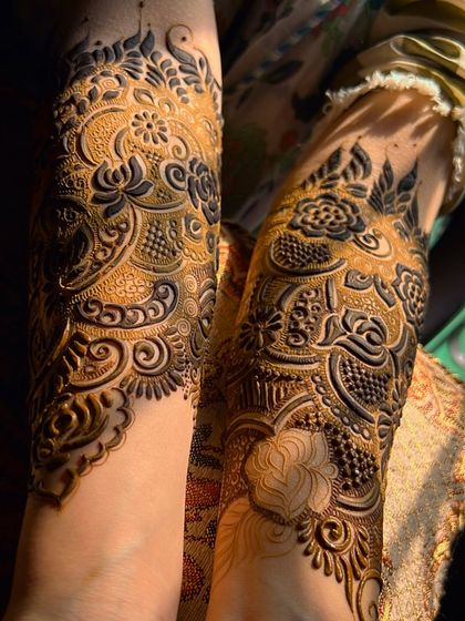 The complete look of the bridal henna, with both arms covered in a symmetrical, detailed design.