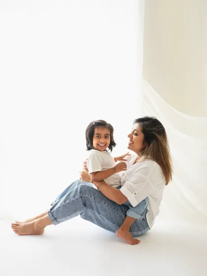 A relaxed and happy mother-daughter portrait from a lifestyle session. The simple white shirts and jeans keep the focus on their beautiful smiles.