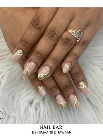 A chic design with a nude base, gold glitter, and delicate white swirls for a modern and artistic look.
