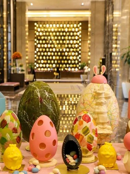 A stunning display of large, artisanal chocolate Easter eggs with intricate designs.